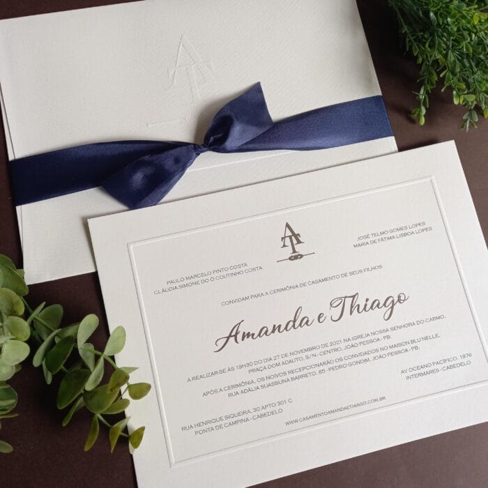 Convite de casamento em papel branco com detalhes em prata e fita azul.