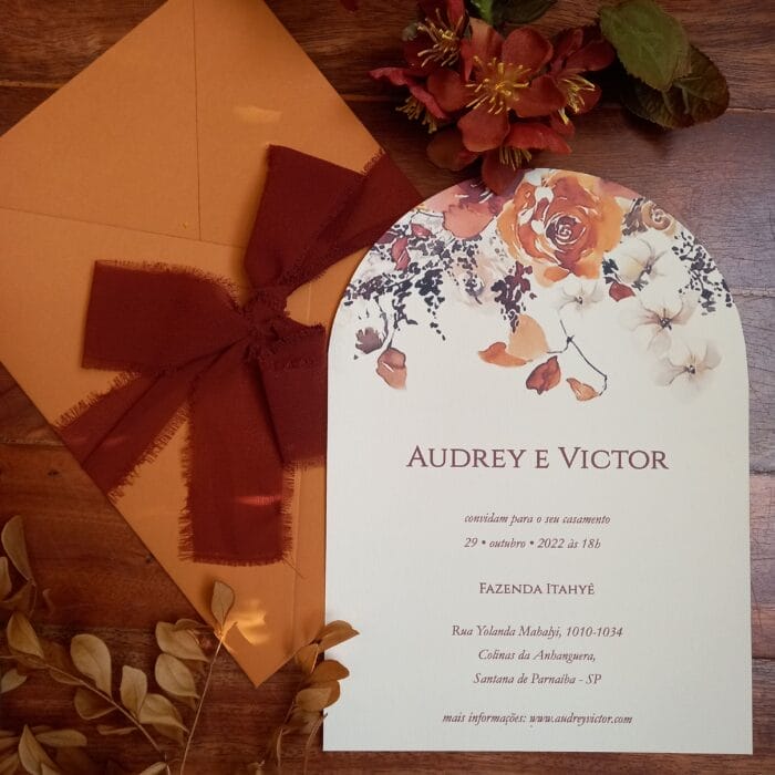 Estilo e tema de convites de casamento 3 Convite de casamento com envelope em FCard Ocre e convite com floral colorido e texto em epóxi com topo arredondado. Laço em fita de tecido terracota.
