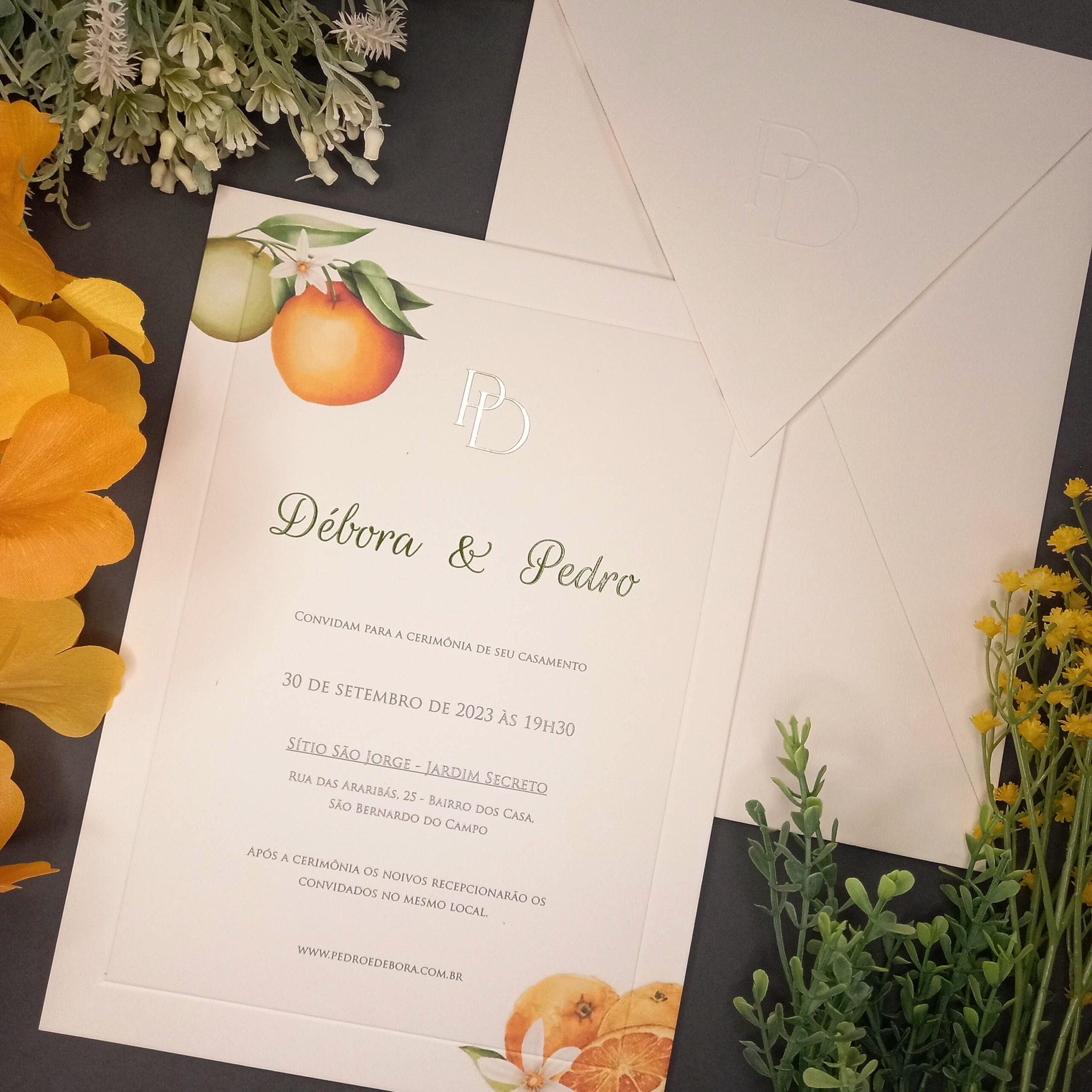 Convite de casamento com tema de laranjas e iniciais em dourado