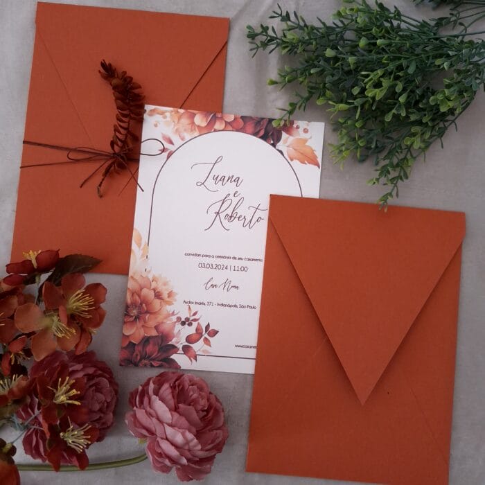 Convite de casamento em tons terracota com folhagem e flores e texto minimalista